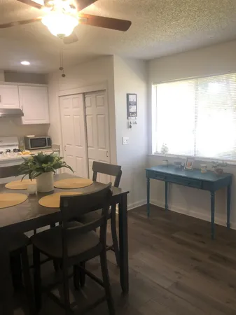 a kitchen with a table chairs a sink dishwasher window and cabinets