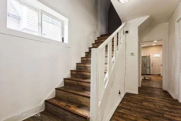 a view of a hallway with wooden floor and staircase