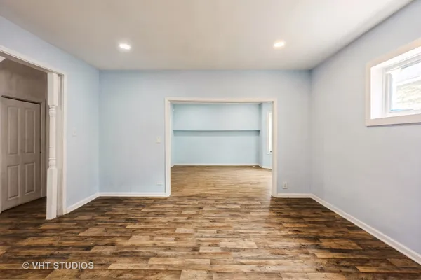 a view of an empty room with wooden floor and closet