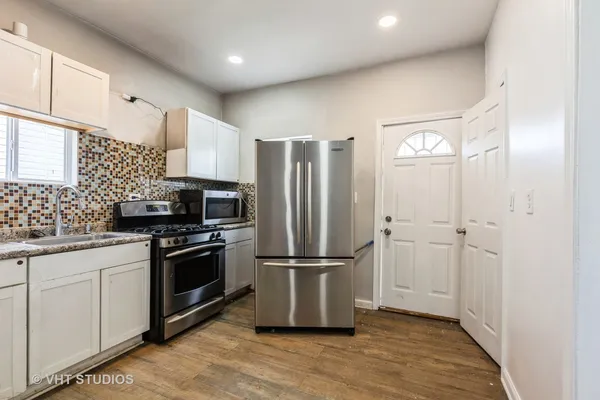 a kitchen with stainless steel appliances granite countertop a refrigerator sink and stove