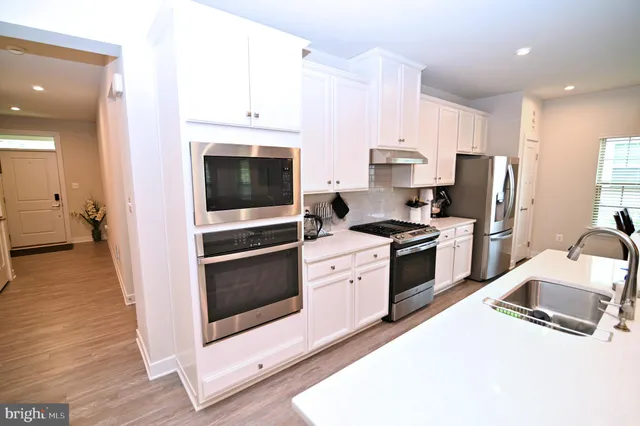 a kitchen with kitchen island a stove a table a sink and cabinets