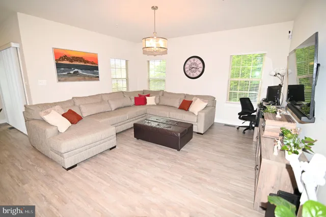 a large kitchen with a table chairs wooden floor and a sink