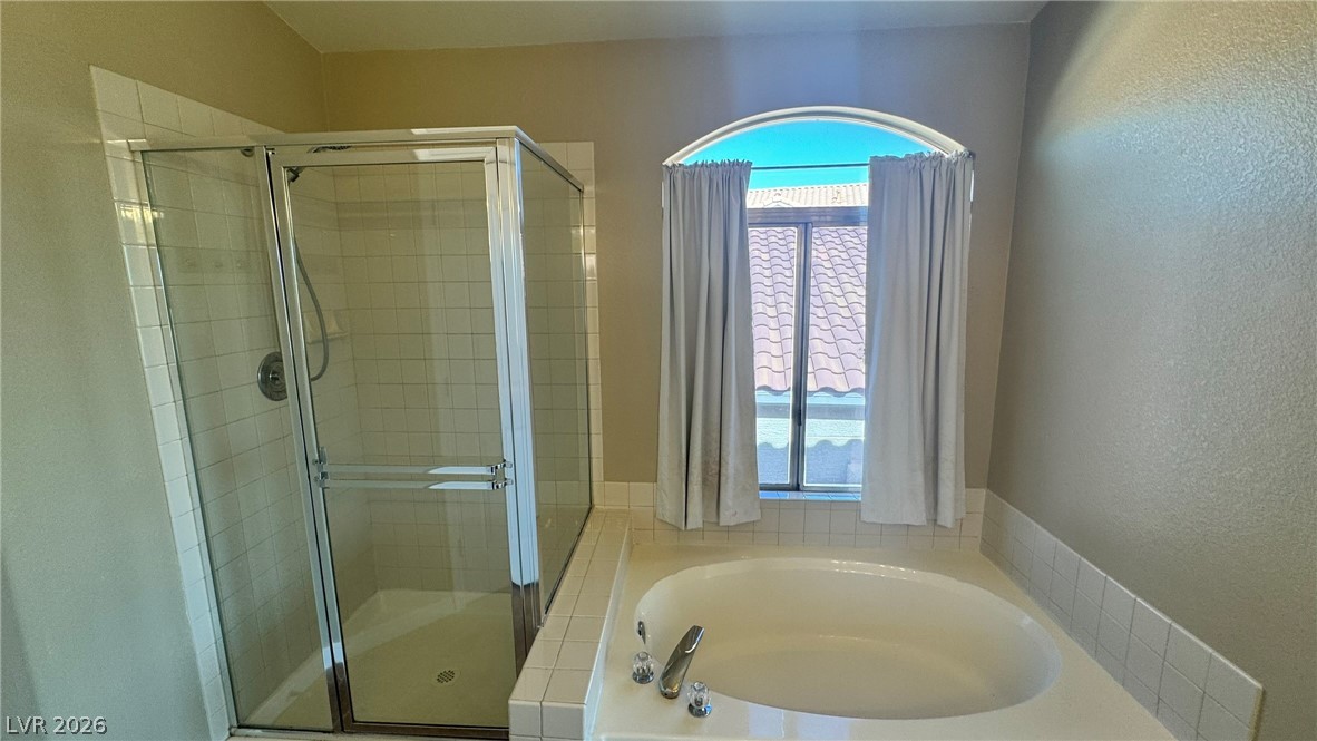 9716 Ridge Creek Place Las Vegas, NV 89134 - Photo 24 of 28 This serene bathroom offers a spacious soaking tub and a clear glass-enclosed shower.