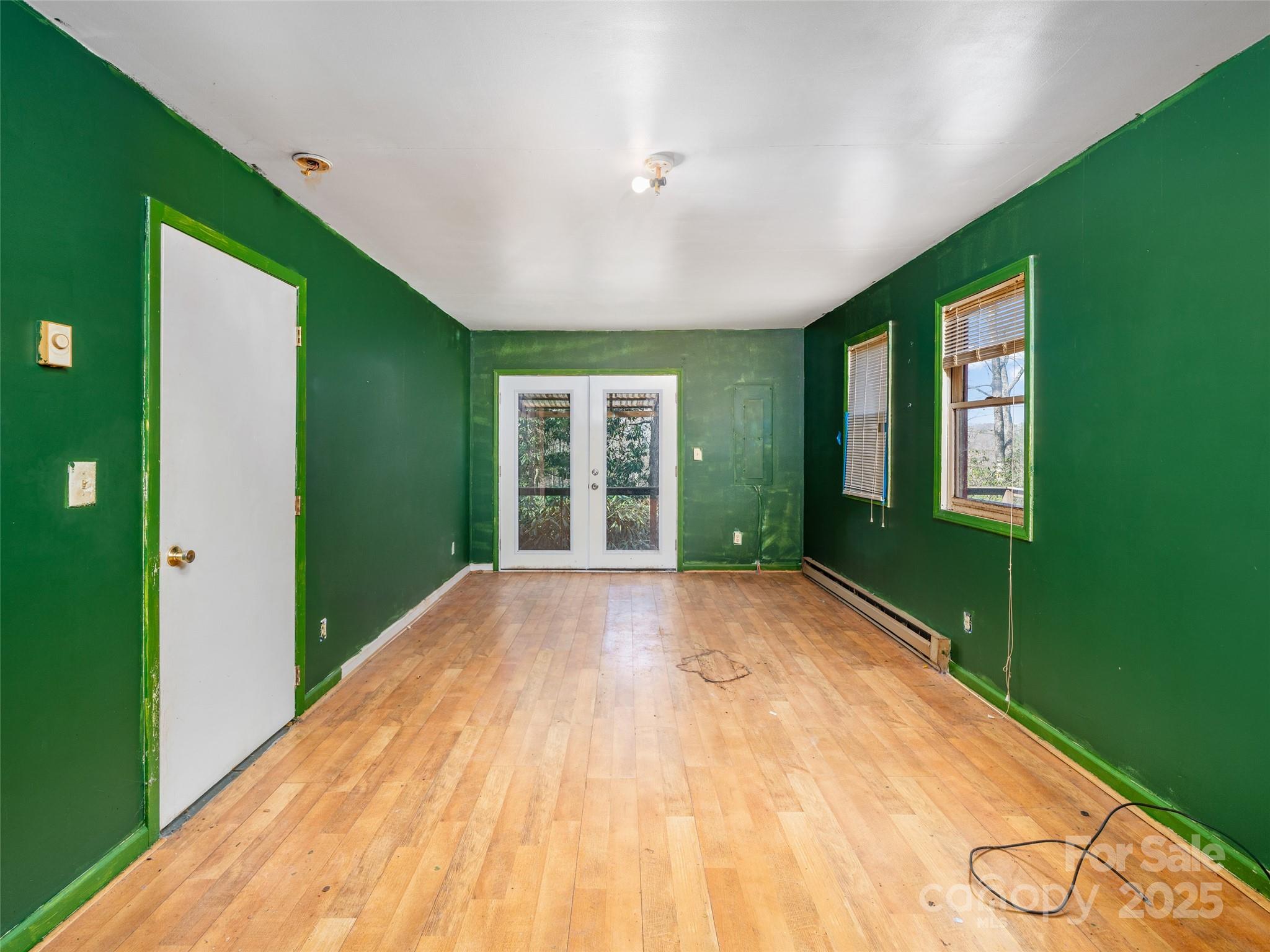 74 George Street Spruce Pine, NC 28777 - Photo 13 of 29 a view of an empty room with a window and wooden floor