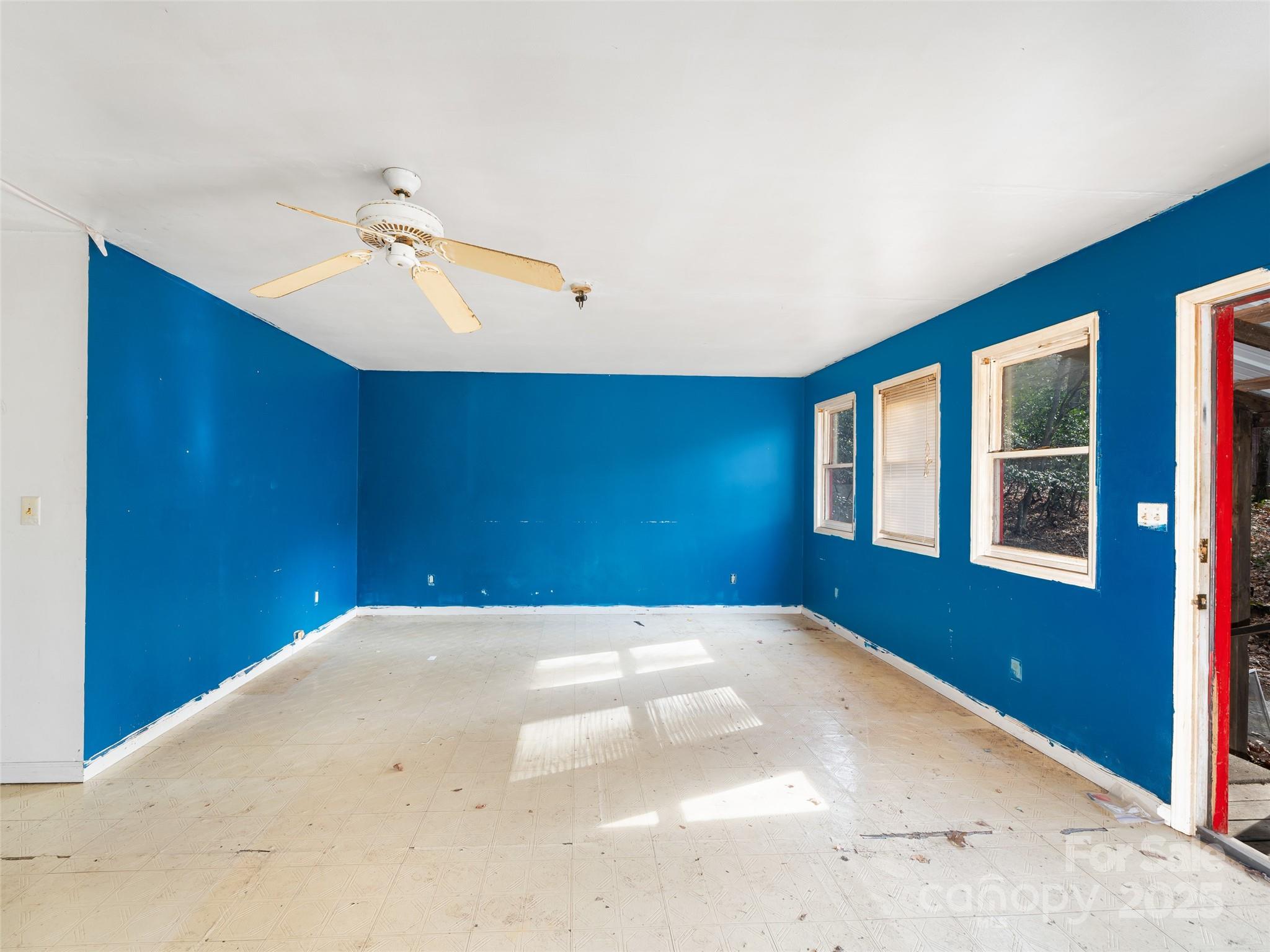 74 George Street Spruce Pine, NC 28777 - Photo 8 of 29 a view of a big room with windows and chandelier fan