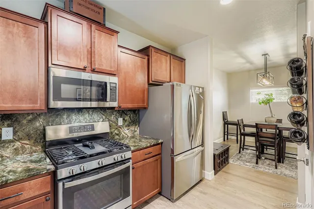 a kitchen with stainless steel appliances granite countertop a stove a refrigerator and a microwave