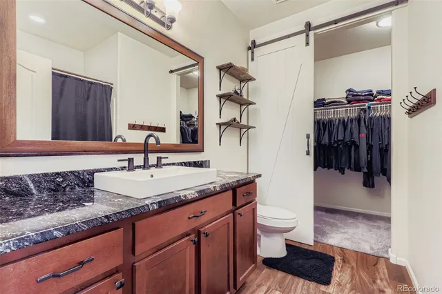 a bathroom with a granite countertop sink a toilet and shower