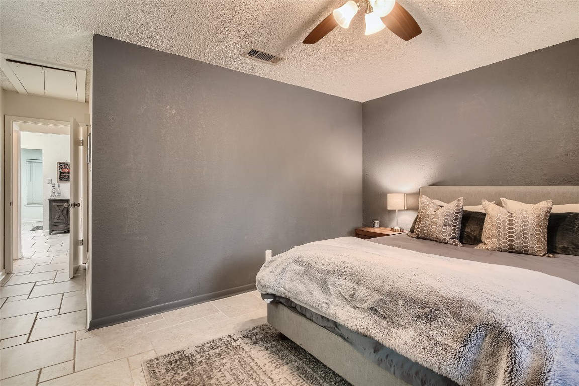 3815 Menchaca Road, Unit 9A Austin, TX 78704 - Photo 11 of 19 a bedroom with a bed and a chandelier fan