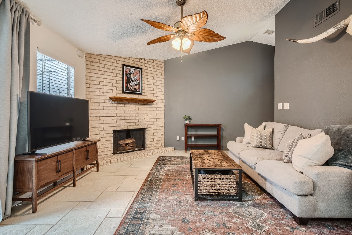 3815 Menchaca Road, Unit 9A Austin, TX 78704 - Photo 2 of 19 a living room with furniture a flat screen tv and a fireplace