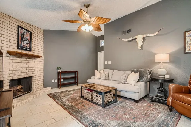 a living room with furniture a fireplace and a chandelier