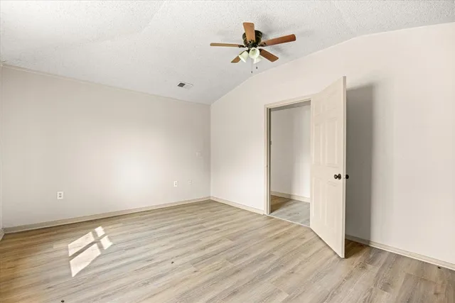 a view of a room with wooden floor and ceiling fan