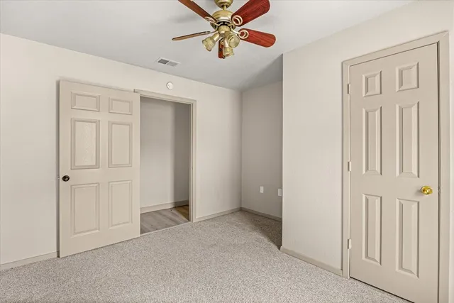 an empty room with closet and windows