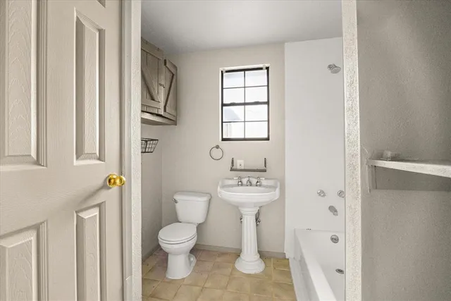 a bathroom with a toilet a sink and a window