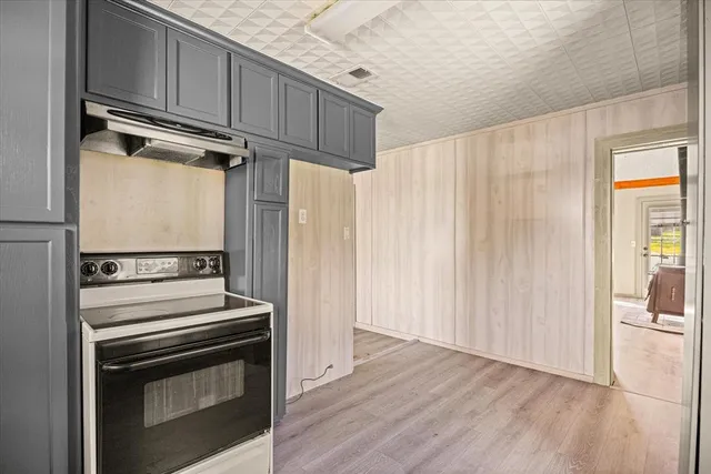 a view of a kitchen with wooden floor electronic appliances and stairs