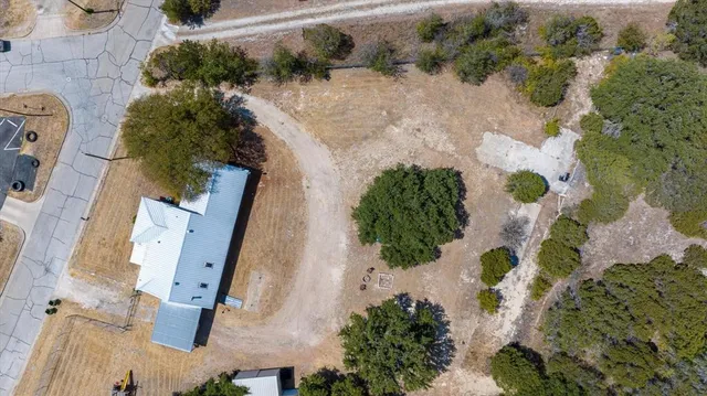 an aerial view of a house with a yard and blue outdoor space