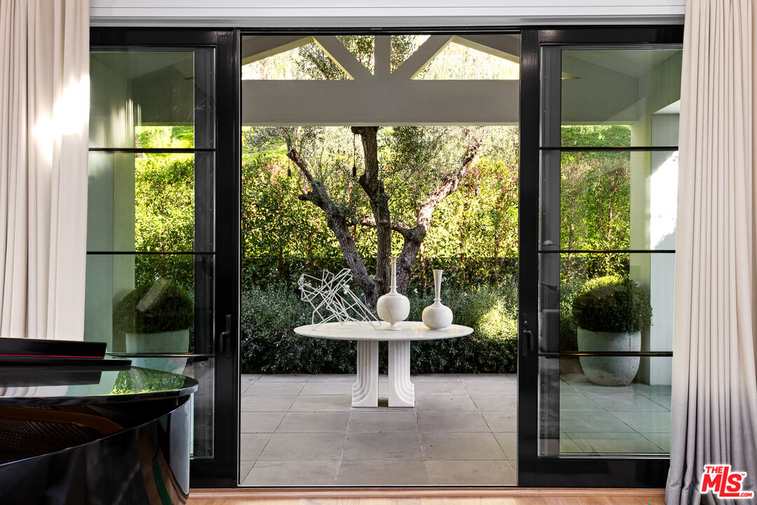 25210 Jim Bridger Road Hidden Hills, CA 91302 - Photo 12 of 65 a view of a living room and floor to ceiling window kitchen