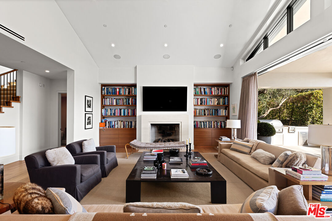25210 Jim Bridger Road Hidden Hills, CA 91302 - Photo 19 of 65 a living room with furniture a flat screen tv and a fireplace