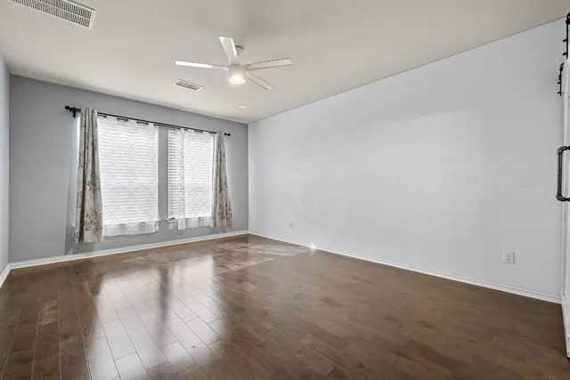 a dining room with wooden floor a glass table and chairs