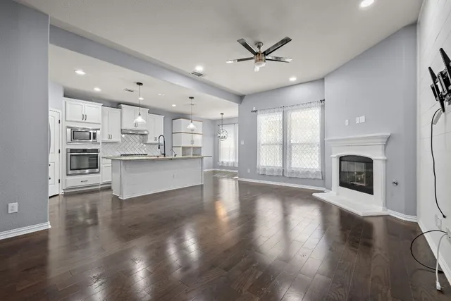 an empty room with windows and a fireplace