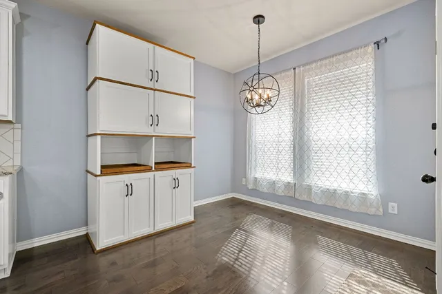 a kitchen with stainless steel appliances granite countertop a sink a stove a refrigerator and island with wooden floor