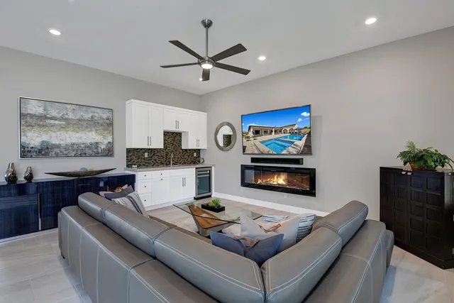 a patio with tables and chairs under an umbrella