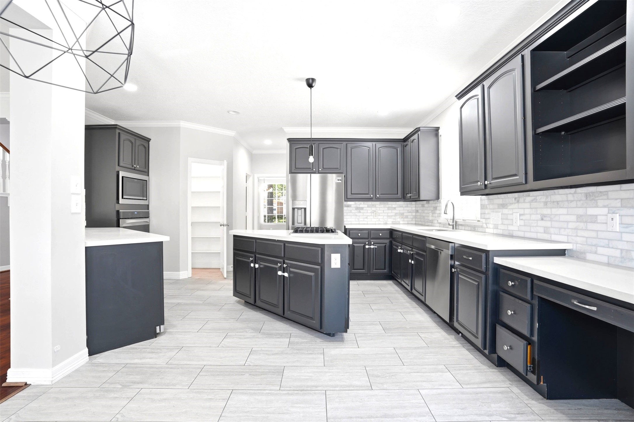 4707 Stackstone Lane Katy, TX 77450 - Photo 13 of 50 a large kitchen with kitchen island granite countertop a stove top oven a sink dishwasher and a refrigerator