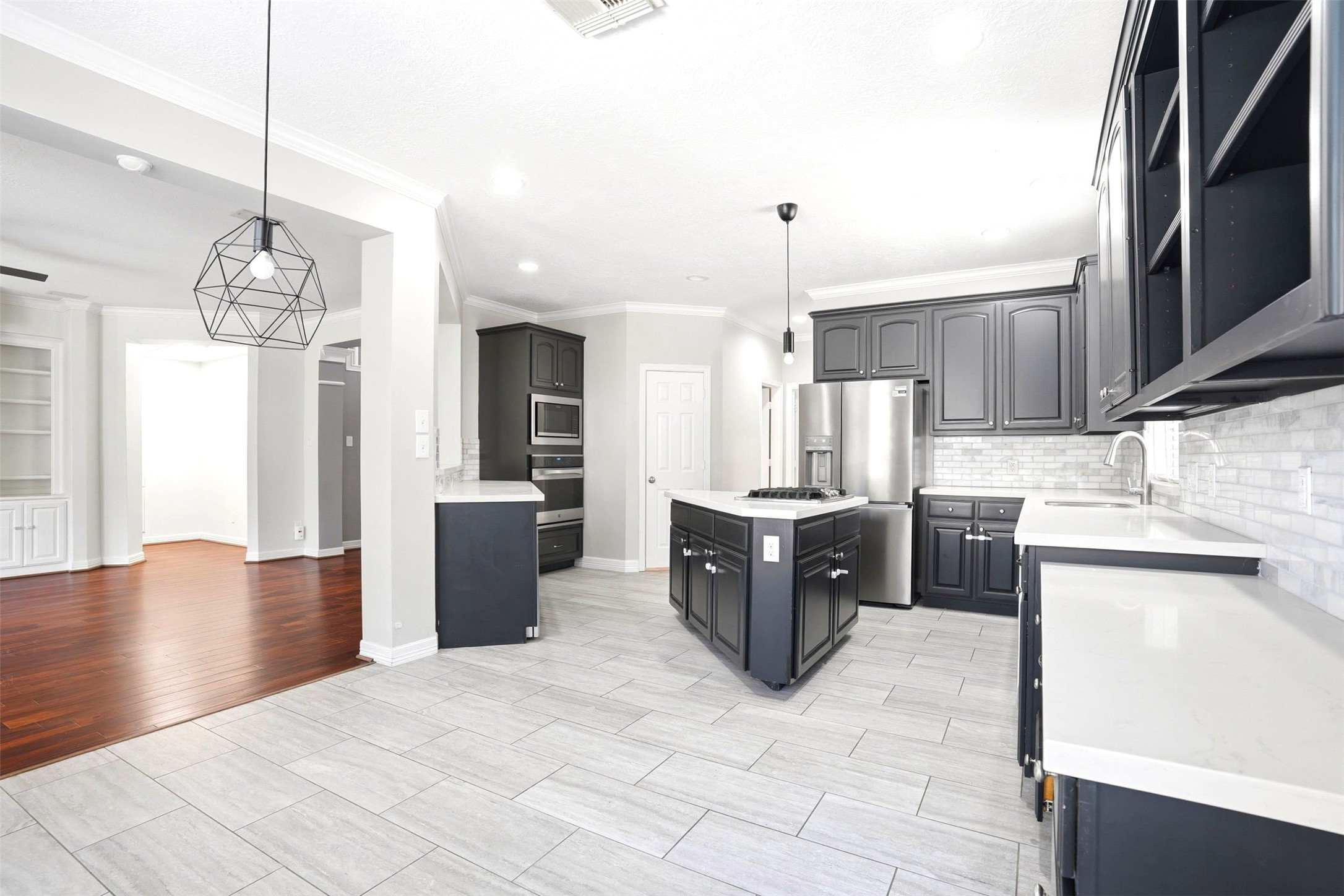 4707 Stackstone Lane Katy, TX 77450 - Photo 14 of 50 a large kitchen with kitchen island a sink stainless steel appliances and cabinets