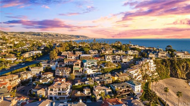 a view of a dining room and livingroom with furniture wooden floor a rug a potted plant and a chandelier