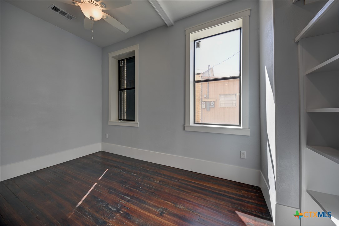 103 North Main Street, Unit B Moulton, TX 77975 - Photo 18 of 28 a view of an empty room with wooden floor and a window