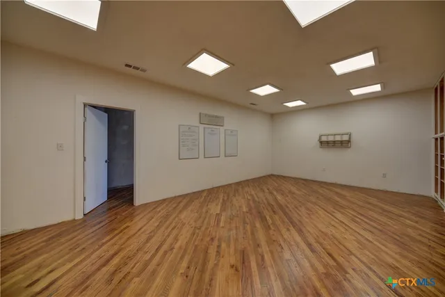 a view of empty room with wooden floor