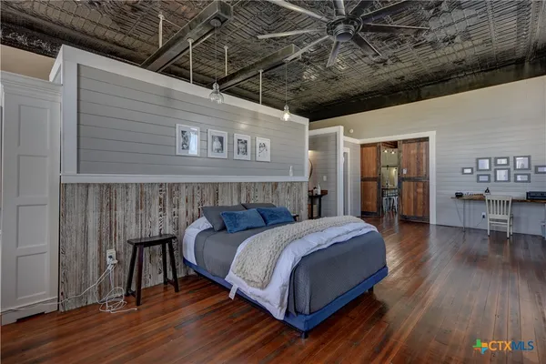 a bedroom with a bed and a wooden floor