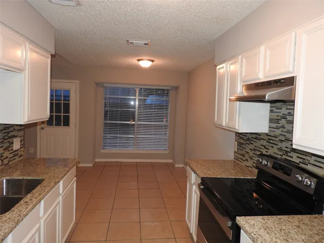 a kitchen that has a sink and a stove in it