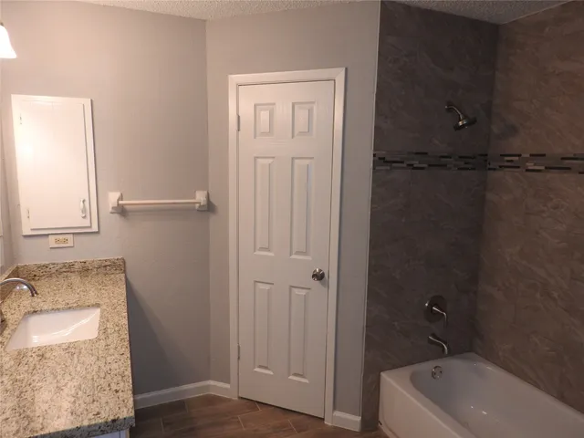 a bathroom with a granite countertop sink toilet and shower
