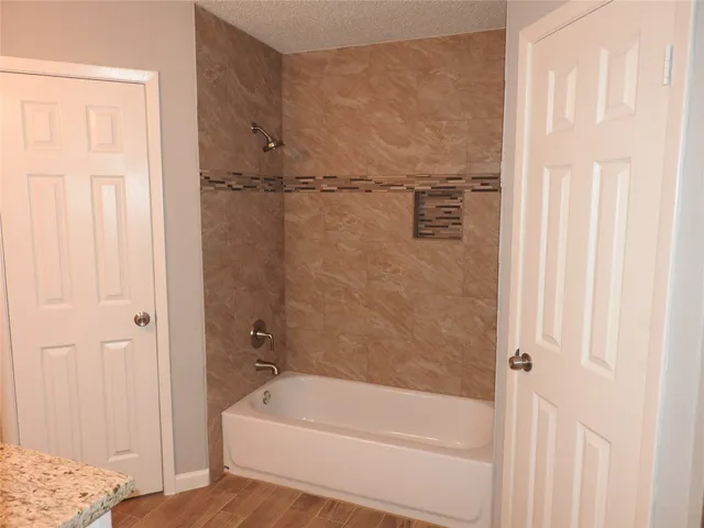 a bathroom with a tub a window and a shower