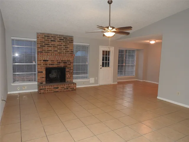 a view of an empty room with a fireplace and a window