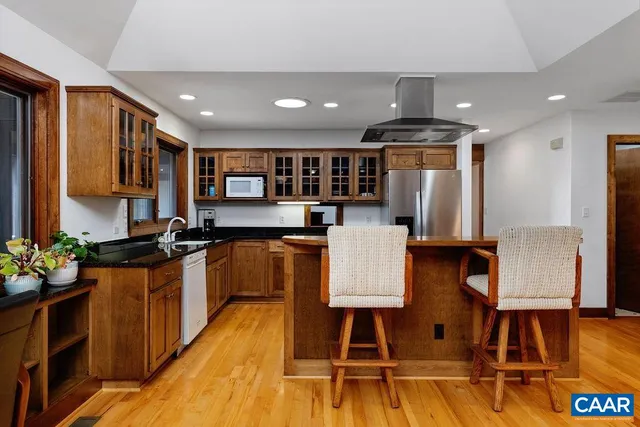 a kitchen with stainless steel appliances granite countertop a refrigerator and a stove top oven