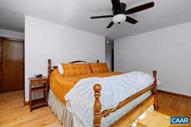 a bedroom with bed and wooden floor