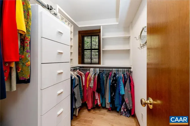 a view of walk in closet with clothes and shoes