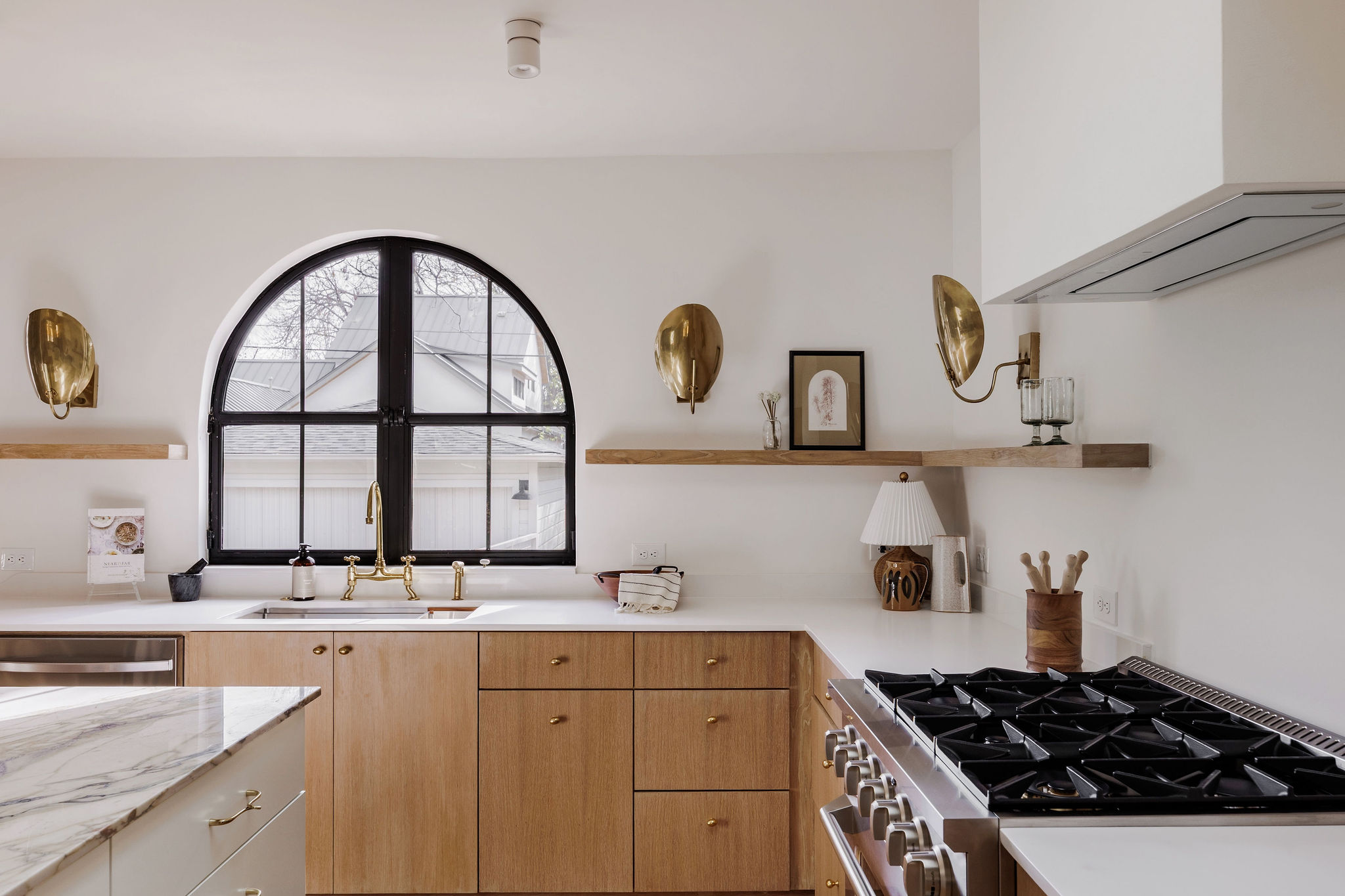 4515 Bull Creek Road Austin, TX 78731 - Photo 7 of 33 Custom rift-cut white oak cabinetry adds warmth and texture, paired with clean floating shelves and curated finishes for a timeless, designer-forward kitchen.