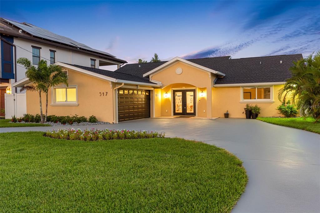 517 Johns Pass Avenue Madeira Beach, FL 33708 - Photo 2 of 92 a front view of a house with a garden