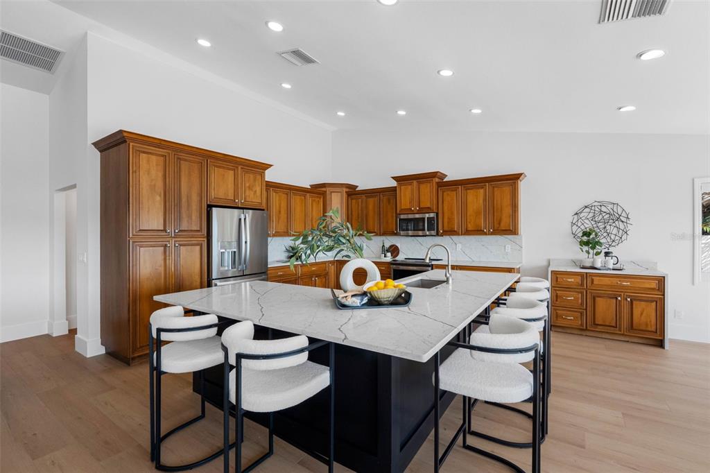 517 Johns Pass Avenue Madeira Beach, FL 33708 - Photo 33 of 92 a kitchen with stainless steel appliances granite countertop a dining table and chairs