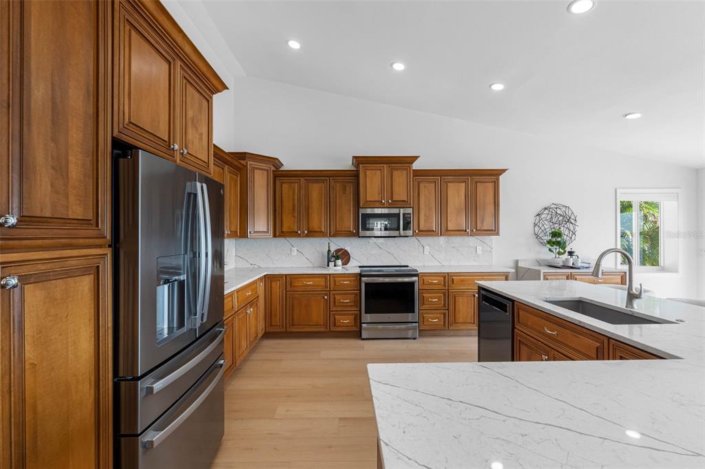 517 Johns Pass Avenue Madeira Beach, FL 33708 - Photo 35 of 92 a kitchen with stainless steel appliances granite countertop a refrigerator a stove and a sink