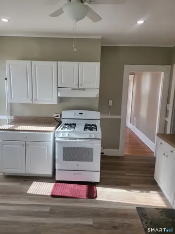 a kitchen with a stove cabinets and wooden floor