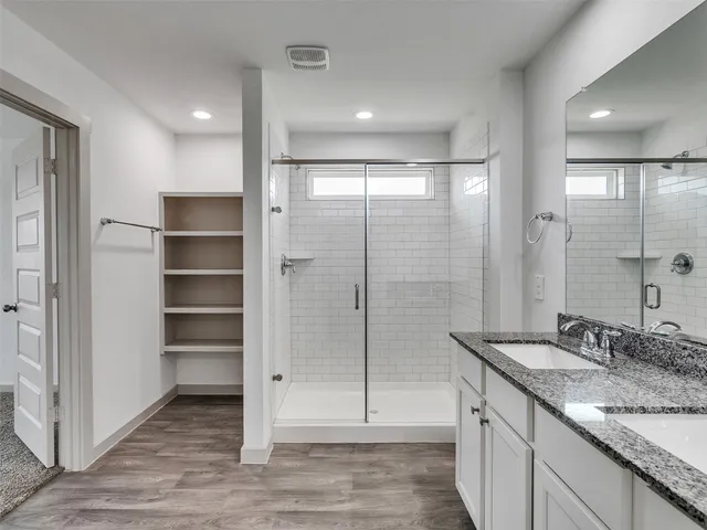 a bathroom with a granite countertop sink mirror and shower