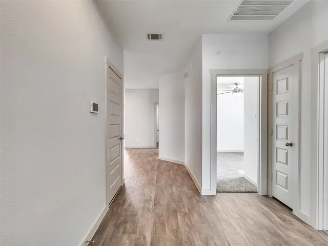 a view of a hallway with wooden floor
