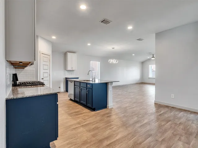 a kitchen with stainless steel appliances granite countertop a large counter top a stove and a refrigerator