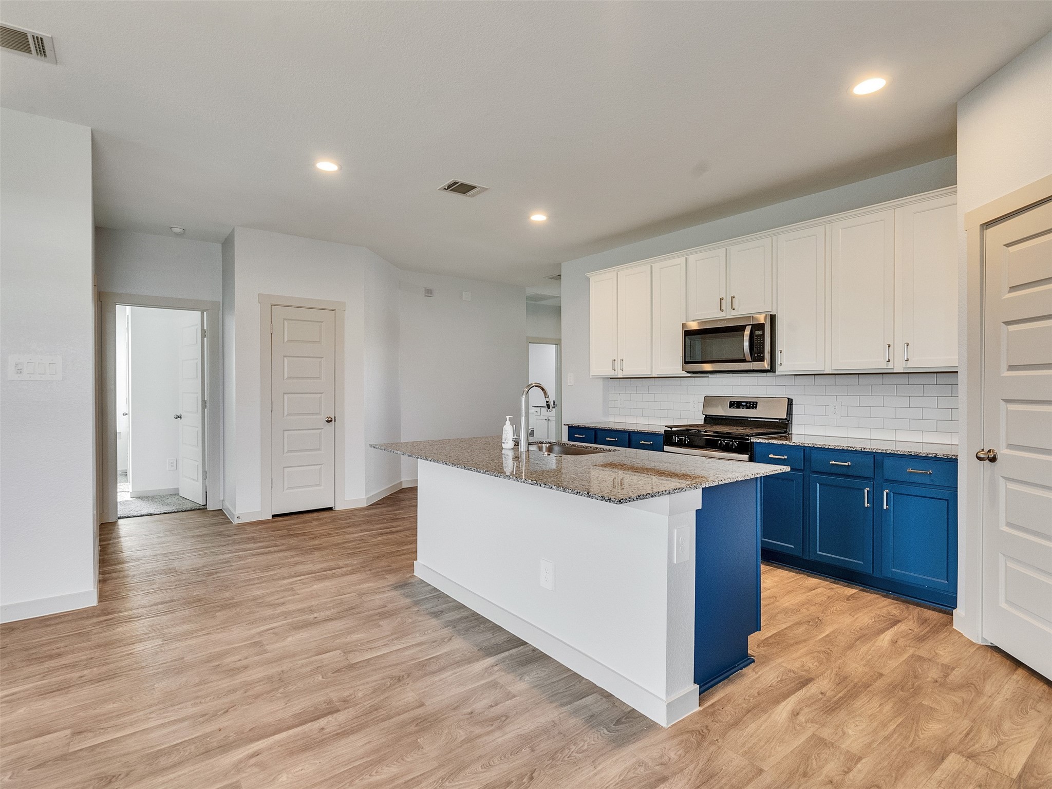10627 Great Basin Drive Rosharon, TX 77583 - Photo 8 of 42 a kitchen with stainless steel appliances granite countertop a stove top oven a sink dishwasher and a refrigerator with wooden floor
