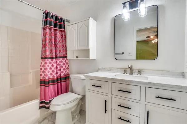 a bathroom with a sink vanity mirror and toilet