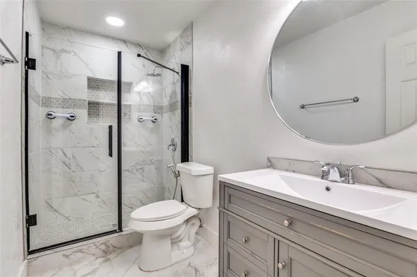 a bathroom with a sink a toilet and shower