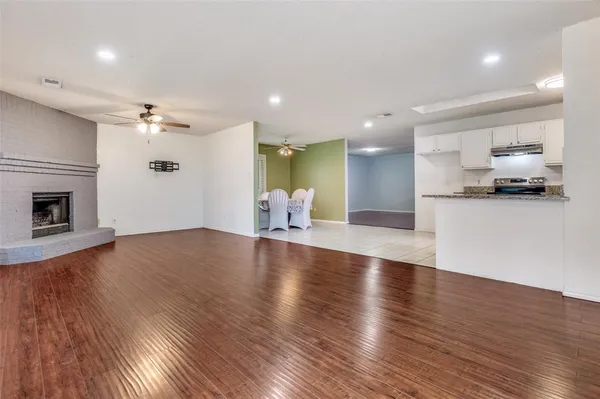 a view of a kitchen with a sink a fireplace and a window